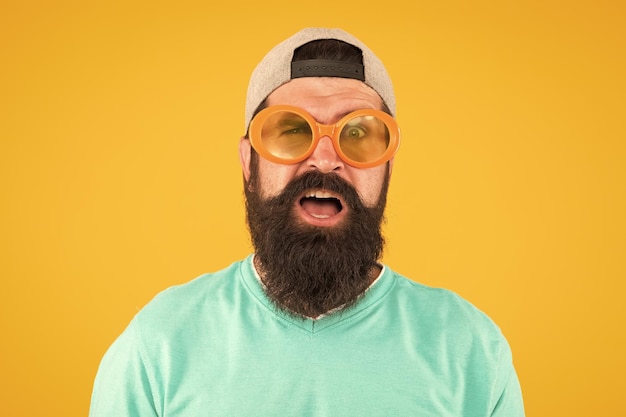 Foto controlli della vista buona visione divertimento e intrattenimento accessorio divertente modello di occhiali da uomo occhiali da sole divertenti uomo barbuto con occhiali da sole sfondo arancione occhiali da sole da festa di usura hipster salute degli occhi