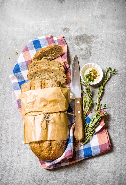 fabric on ciabatta with rosemary and a knife. On the stone table. Top view