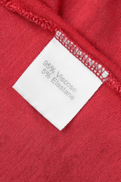 赤い布の背景のクローズ アップの布組成服ラベル