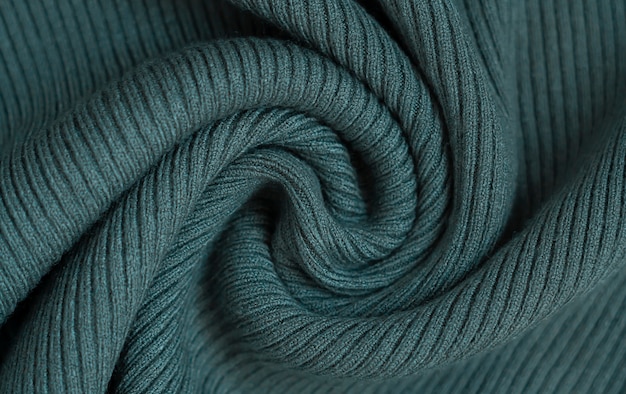 Fabric dark green background. Warm knitted sweater texture