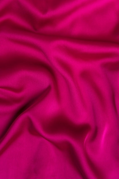 Tessuto color fucsia o color cremisi trama di tessuto rosa brillante di seta o raso cornice astratta di sfondo verticale