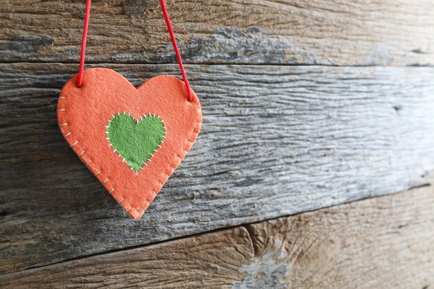 Fabric heart hanging on wooden surface