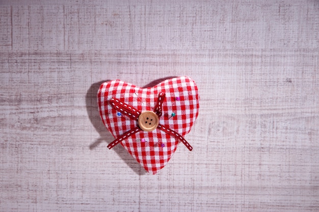 Fabric heart with color  pins on wooden