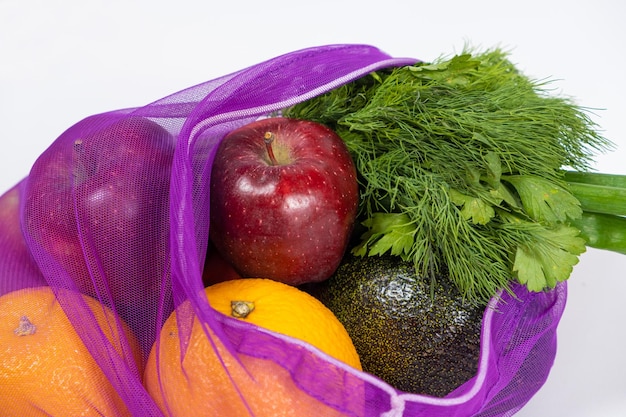 白い背景の上の果物と野菜のファブリック メッシュ ビニール袋の再利用可能な代替