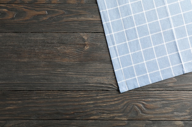 Fabric napkin on wooden background, space for text