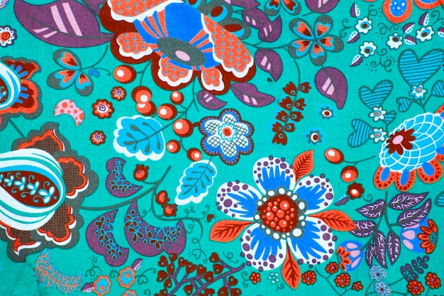 fabric pattern with classical image of the colorful flowers on blue background.