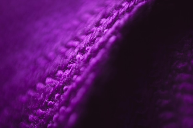 Fabric texture background of purple color (very peri). close up of clothes as wallpaper