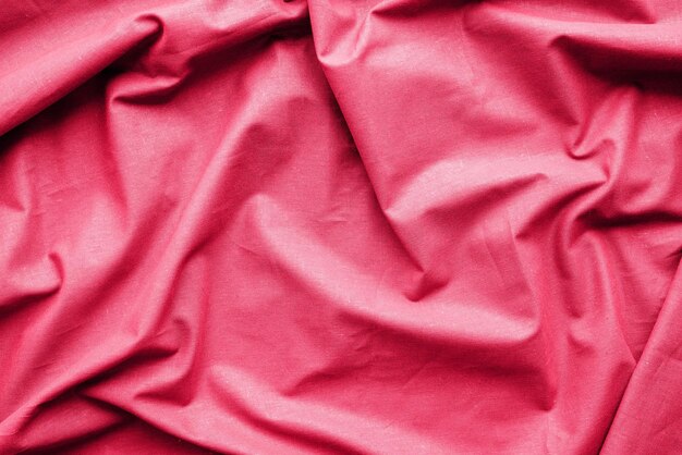 Fabric texture background toned with Viva Magenta color wavy fabric
