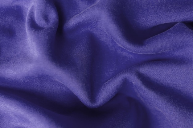 Fabric with waves colored in violet color of the year 2022. Trendy color very peri. Fabric backdrop, cloth texture, view from above.