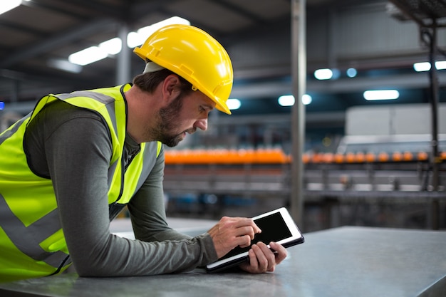 Fabrieksarbeider die een digitale tablet gebruiken