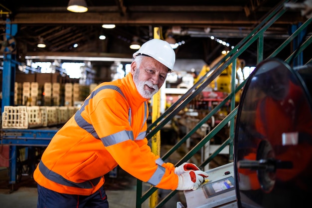 Fabrieksarbeider die industriële machine in productiehal bedient.