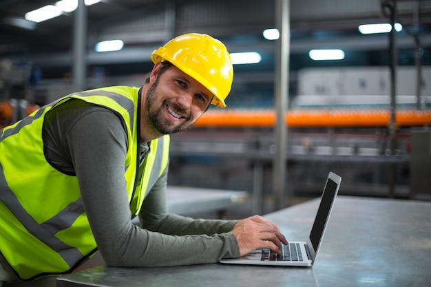 Fabrieksarbeider die laptop met behulp van