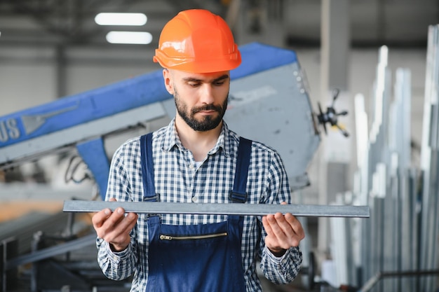 Fabrieksarbeider meet het metalen profiel