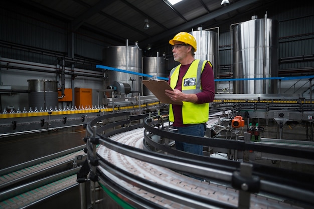 Fabrieksarbeider met klembord werken in de fabriek