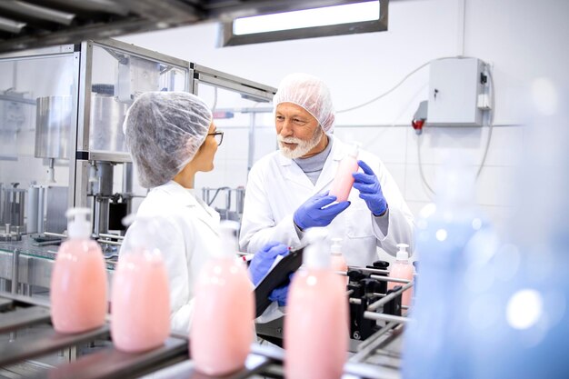 Foto fabrieksarbeiders discussiëren over de productkwaliteit in de sanitaire productie-installatie