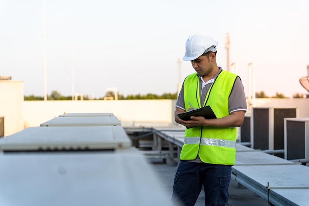 Fabrieksmonteurs lopen en controleren het koelsysteem van de fabriek. Voorman registreert de toestand van de compressor vóór onderhoud volgens onderhoudsplan