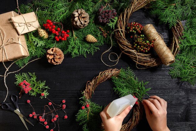 Fabrikant van kerstdecor met hun eigen handen kerstkrans voor de vakantie het nieuwe jaar c...