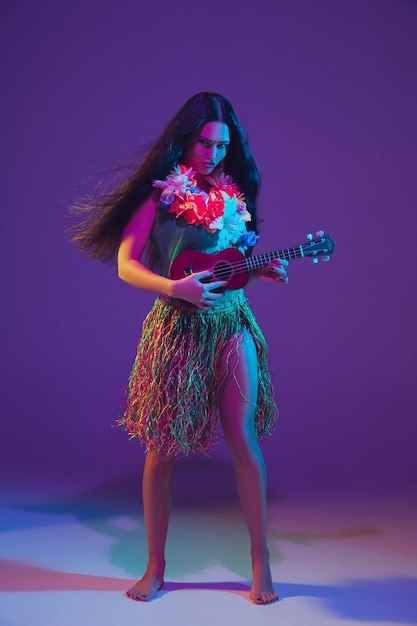 Fabulous Cinco de Mayo female dancer on purple studio wall in neon light