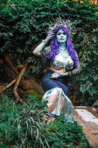 fabulous dark mermaid with blue skin in the forest closeup