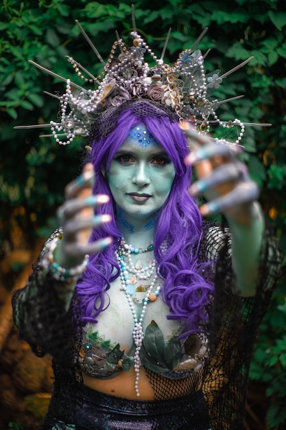 fabulous dark mermaid with blue skin in the forest closeup