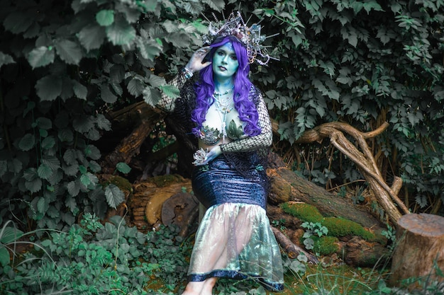 fabulous dark mermaid with blue skin in the forest closeup