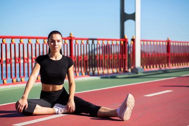 Fabulous fitness girl stretching legs workout before run. Space for text