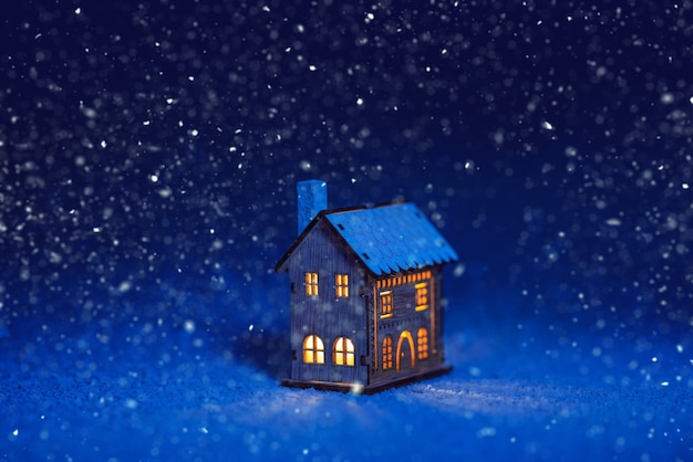 夜の雪の中で素晴らしい小さな家
