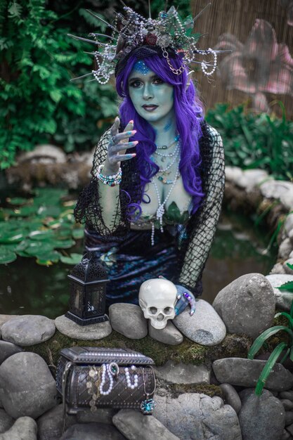 fabulous mermaid siren in a pond with a skull closeup