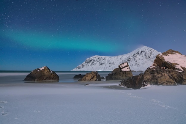 Foto meravigliosi paesaggi invernali sulla spiaggia di skagsanden di notte con le luci del nord destinazione turistica popolare ubicazione isola di flakstadoya lofoten norvegia europa