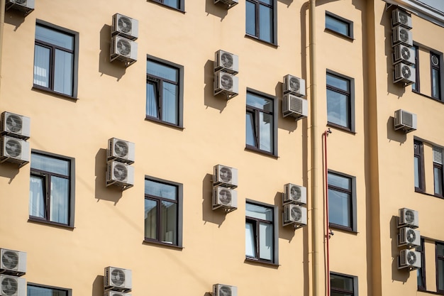 Facade of building with many air conditioners on windows in southern hot country