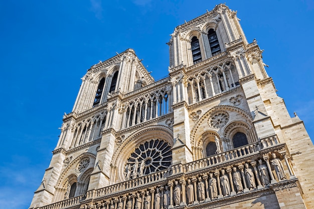 Foto facciata della cattedrale notre-dame de paris contro il cielo blu a parigi, francia