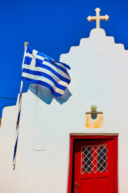 ギリシャの旗を持つギリシャ正教会のファサード、ミコノス島、ギリシャ