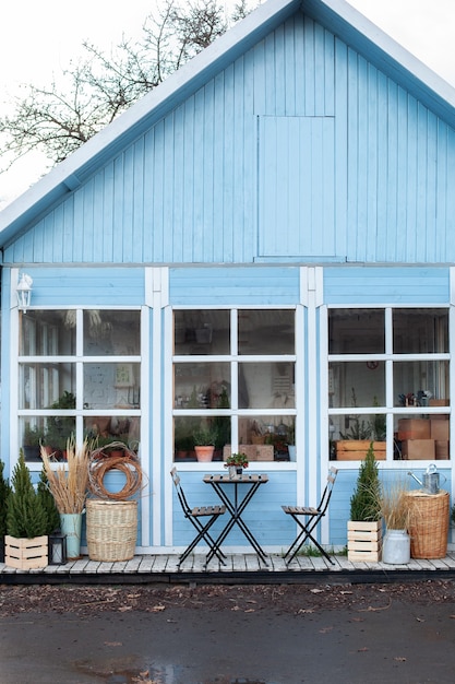 facade home with wicker baskets, wooden table and chairs on porch