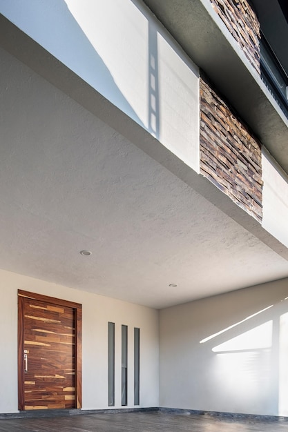 Facade of a modern house with stone staple that wraps the windows painted in gray metal entrance ironwork