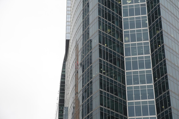 Facade of modern skyscraper with glass walls From below of contemporary tall skyscraper with glass walls against cloudy sky in downtown