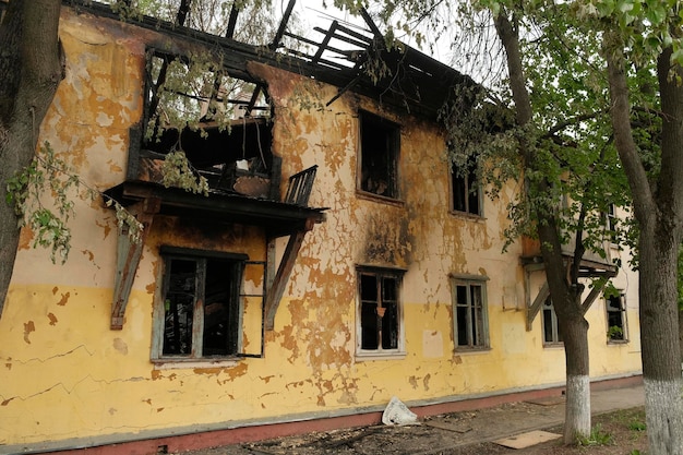 写真 火災の後古い二階建ての家の正面燃やされた住宅ビル
