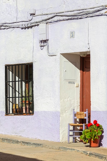 Facade of old house with wooden chair at the door next to a pot of geraniums in Fuendetodos hometown of Spanish painter Francisco De Goya Zaragoza Autonomous Community of Aragon Spain