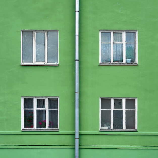 Photo facade of old residental buildning with windows and a drainpipe