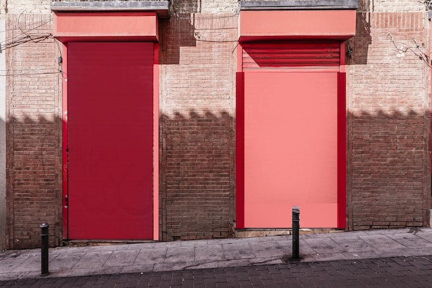 Photo facade of a reddish colored commercial premises on a street with bollards