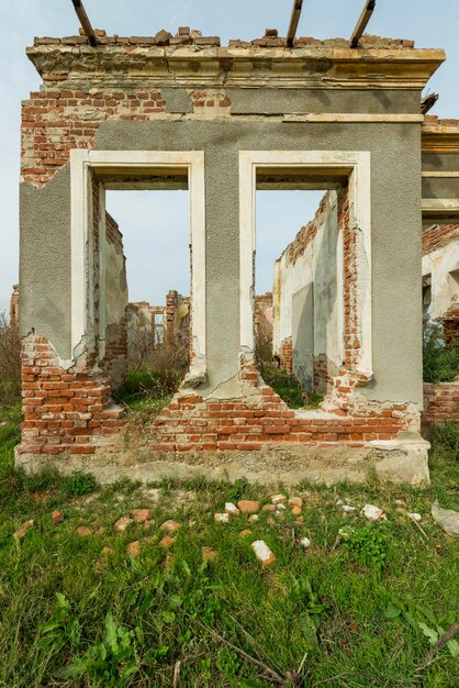 Foto facciata di un edificio in rovina con finestre e mattoni di argilla