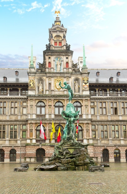 Photo facade of stadhuis (city hall) and medieval brabo fountain , antwerpen, belgium