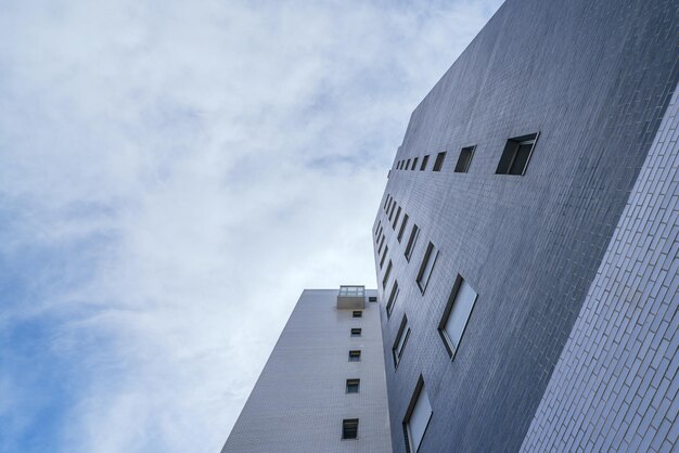 Facade of urban residential building of gray color at low angle