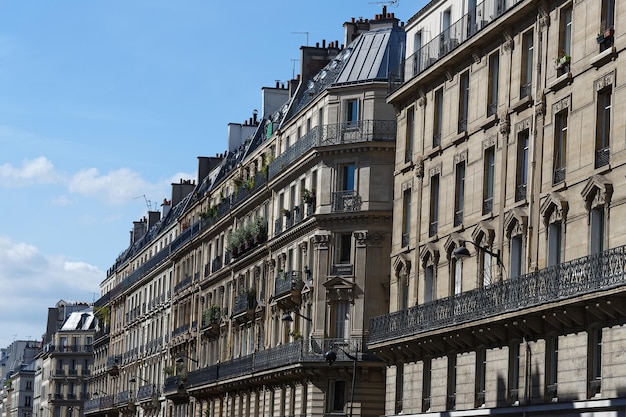 The facades of traditional French houses with typical balconies and windows Paris