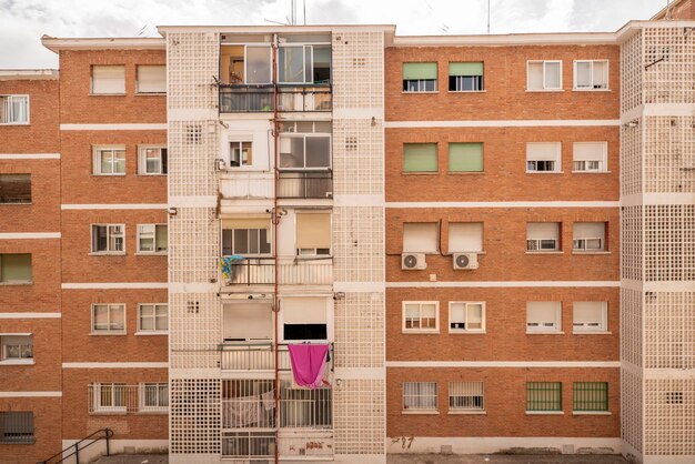 Photo facades of urban houses with many twin windows and lattices built with glass paves and white cement