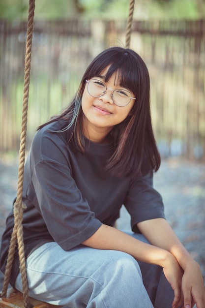 Face of asian teenager relaxing on rope swing