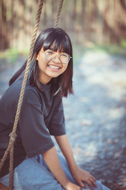 Face of asian teenager relaxing on rope swing