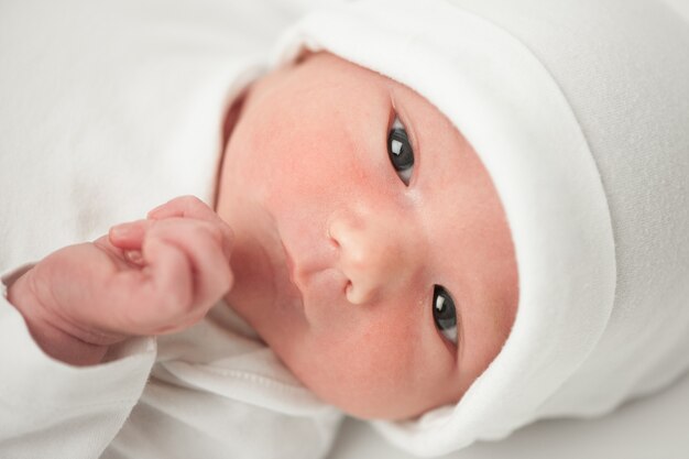 Face baby in a white hat on a white background