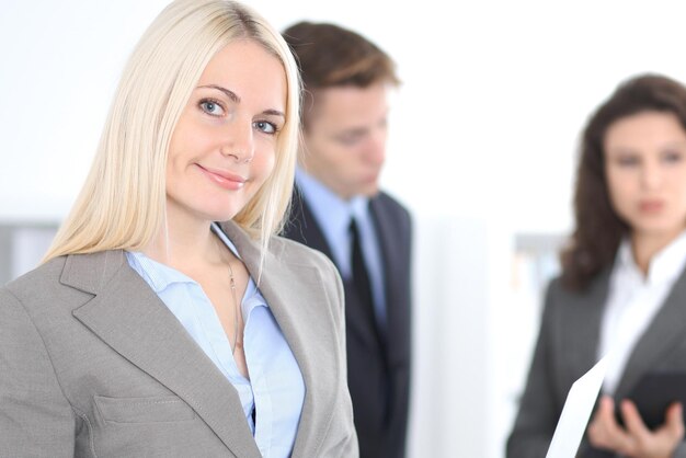 Face of beautiful cheerful smiling woman on the background of business people.