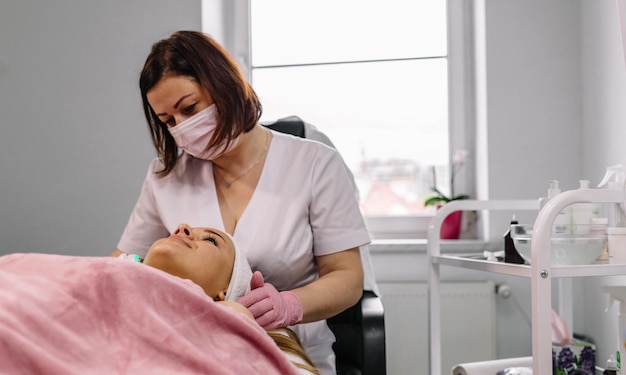 Face of beautiful woman while procedure jet peeling facial treatment