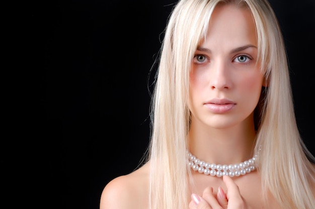 真珠の首飾りの美しい若い女性の顔
